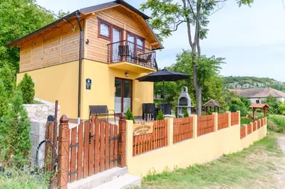 a house with a wooden fence and a balcony at Green House Latin Grad in Vrmdža