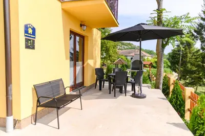 a patio with a table and chairs and an umbrella at Green House Latin Grad in Vrmdža