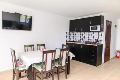 a kitchen with a table and chairs and a microwave at Green House Latin Grad in Vrmdža