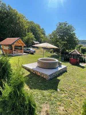 a table with an umbrella in a yard at Green House Latin Grad in Vrmdža