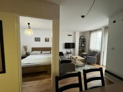 a bedroom with a bed and a living room at Sailboat Apartment in Niš