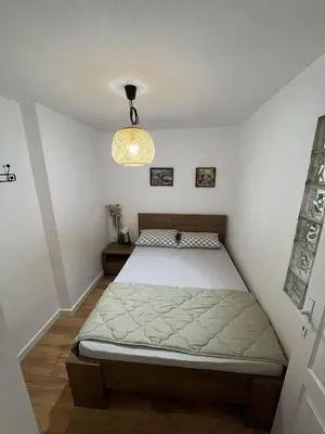 a bedroom with a bed and a chandelier at Sailboat Apartment in Niš