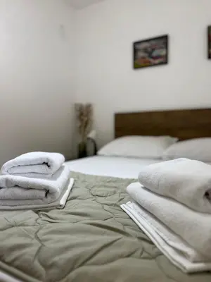 a bed with towels stacked on top of it at Sailboat Apartment in Niš