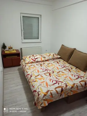 a bedroom with a bed with a colorful comforter at Mila lux in Niš