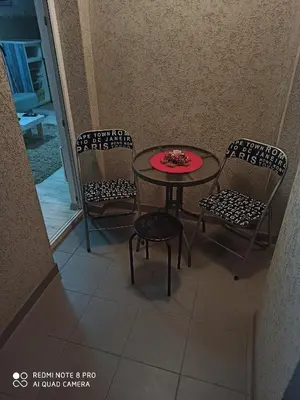 a table with two chairs and a red plate on it at Mila lux in Niš