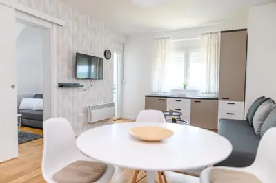a white living room with a white table and chairs at AQUA LUX - Green Hill - Kod akva parka Podina in Soko Banja