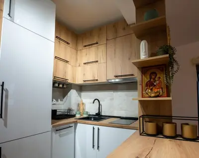 a kitchen with wooden cabinets and a white refrigerator at Apartman Nest in Vranje