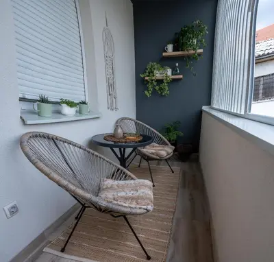 two chairs and a table in a room with a window at Apartman Nest in Vranje
