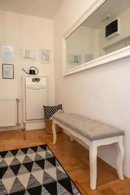 a white bench in a room with a window at Apartman Nest in Vranje