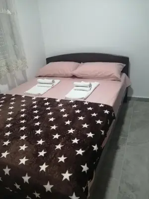 a bed with a black blanket with white stars on it at Apartman Jela in Soko Banja