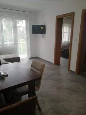a living room with a table and a couch and a television at Apartman Jela in Soko Banja
