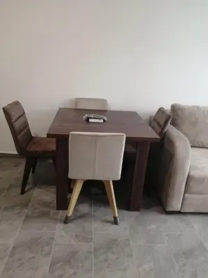 a wooden table with a chair and a couch at Apartman Jela in Soko Banja