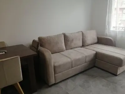 a brown couch in a living room with a table at Apartman Jela in Soko Banja