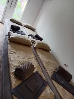 a bed in a room with two mop at Apartman 4M in Vrnjačka Banja
