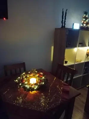 a dining room table with a candle and lights on it at Apartman 4M in Vrnjačka Banja