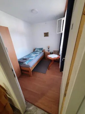a small room with a bed and a table at Apartman Tupavica in Pirot
