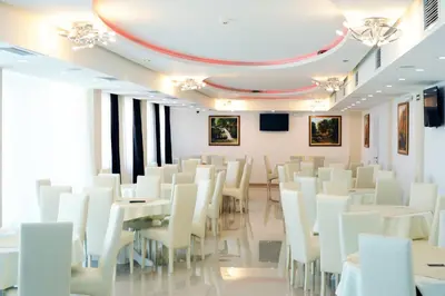 a room with white tables and white chairs at Garni Hotel Crystal Ice in Niš