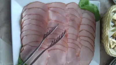 a plate of meat with a pair of tongs on it at Garni Hotel Crystal Ice in Niš