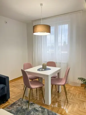 a dining room with a white table and chairs at A1 Miladinovic in Kraljevo