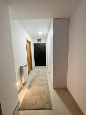 a hallway with white walls and a black door at A1 Miladinovic in Kraljevo