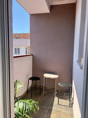 a balcony with two stools and a table at A1 Miladinovic in Kraljevo