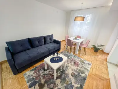 a living room with a blue couch and a table at A1 Miladinovic in Kraljevo