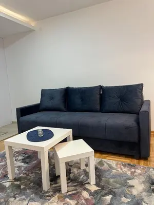 a living room with a blue couch and a coffee table at A1 Miladinovic in Kraljevo