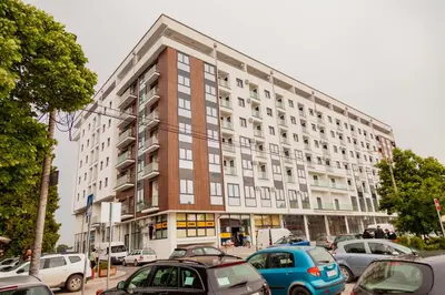 a large building with cars parked in front of it at Aqua Lux Apartman in Jagodina