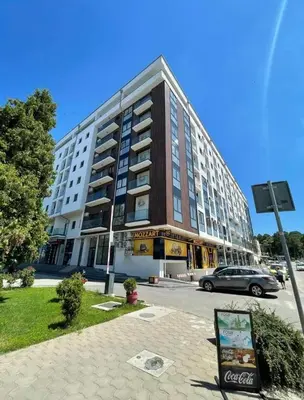 a large building with a car parked in front of it at Aqua Lux Apartman in Jagodina
