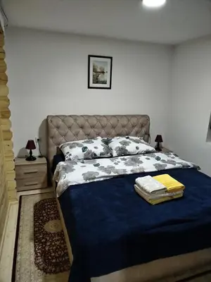 a bedroom with a bed with a blue blanket and pillows at Milica 2 Mezdrejska 87 A in Crni Vrh