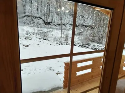 a view of a snow covered yard through a window at Milica 2 Mezdrejska 87 A in Crni Vrh