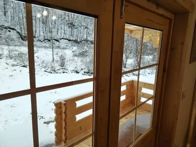 a window in a cabin with snow on the ground at Milica 2 Mezdrejska 87 A in Crni Vrh
