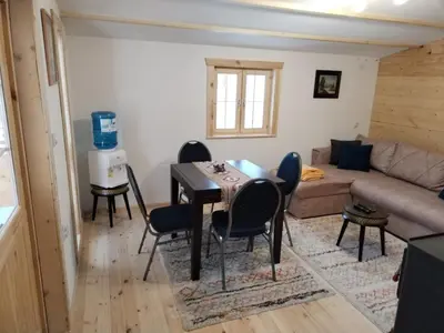 a living room with a table and chairs and a couch at Milica 2 Mezdrejska 87 A in Crni Vrh