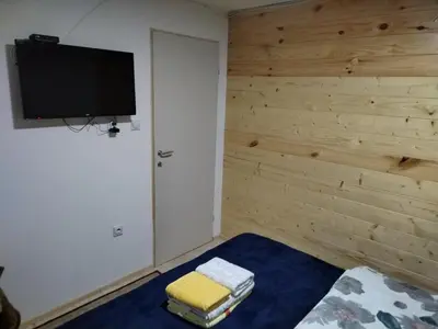 a room with a bed and a television on a wall at Milica 2 Mezdrejska 87 A in Crni Vrh