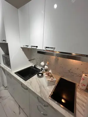 a white kitchen with a sink and a counter at Apartman Polo in Jagodina