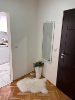 a room with a white rug and a mirror at Apartman Polo in Jagodina