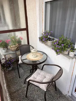 a table and chairs on a balcony with potted plants at Apartman Polo in Jagodina