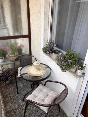 a table and chairs on a balcony with flowers at Apartman Polo in Jagodina