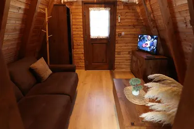 a living room with a couch and a tv at Magareće Mleko Eko Farma Sisevac Wellness&Spa in Paraćin