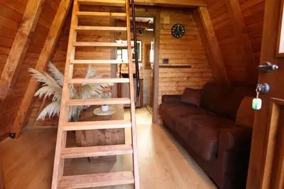a wooden ladder in a living room with a couch at Magareće Mleko Eko Farma Sisevac Wellness&Spa in Paraćin