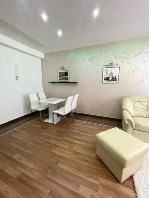 a living room with a table and chairs and a couch at Apartman IN in Vrnjačka Banja