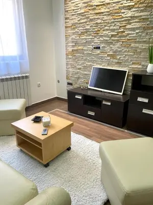 a living room with a tv and a coffee table at Apartman IN in Vrnjačka Banja