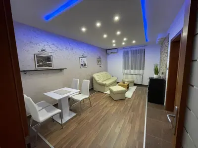 a living room with a couch and a table and chairs at Apartman IN in Vrnjačka Banja