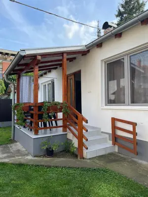 a small white house with a porch and stairs at Rustic Villa in Jagodina