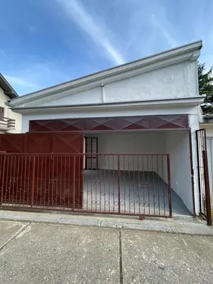 a garage with a red gate in front of a house at Rustic Villa in Jagodina