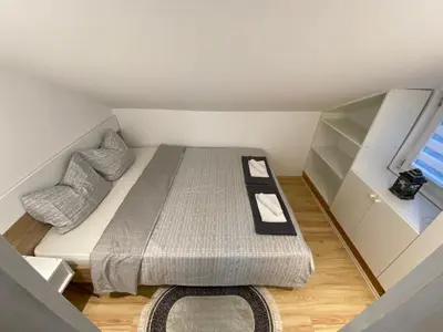 a small bedroom with a bed and a window at Queen Apartmančić in Zaječar