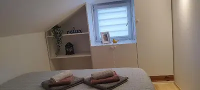 a bedroom with a bed with three pillows on it at Queen Apartmančić in Zaječar