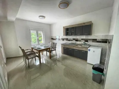 a kitchen and dining room with a table and chairs at Apartman Cvetkovic in Vranje