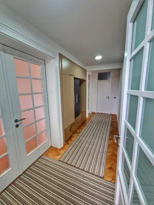 an empty hallway with a door and a rug at Apartman Cvetkovic in Vranje