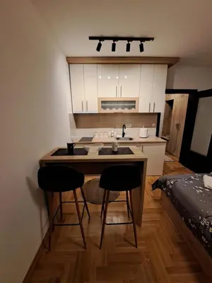 a small kitchen with a table and two chairs at Apartman Imperator Vrnjačka Banja in Vrnjačka Banja